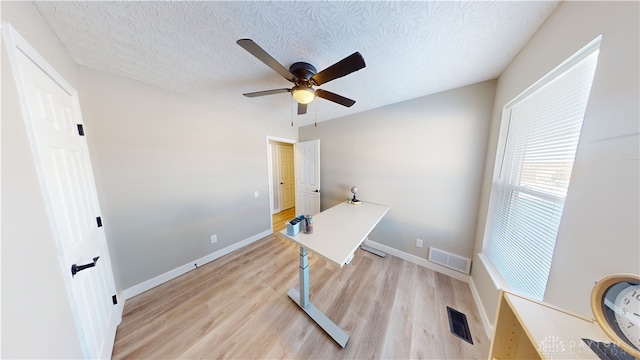 office space featuring ceiling fan, light hardwood / wood-style flooring, and a textured ceiling