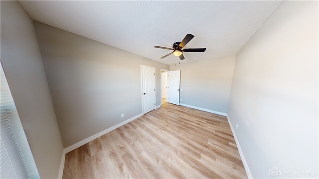 spare room featuring ceiling fan, light hardwood / wood-style flooring, and a textured ceiling