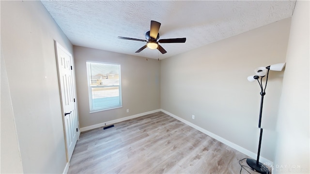 unfurnished room featuring ceiling fan, a textured ceiling, and light hardwood / wood-style flooring