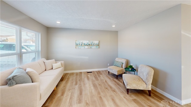 sitting room with light hardwood / wood-style floors and a textured ceiling