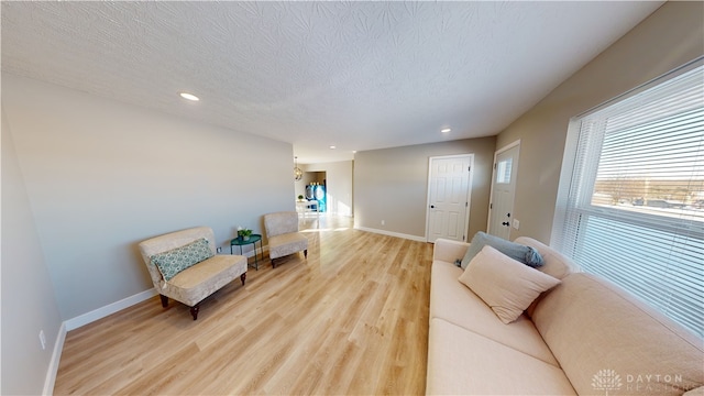 living room with light hardwood / wood-style flooring and a textured ceiling