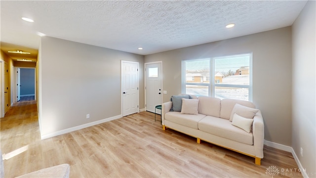 living room featuring a textured ceiling and light hardwood / wood-style flooring