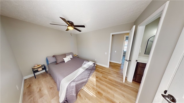 bedroom featuring light hardwood / wood-style floors, a textured ceiling, and ceiling fan