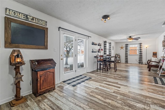 interior space with ceiling fan, a textured ceiling, and hardwood / wood-style floors