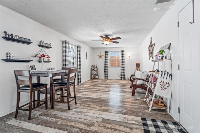 dining room featuring hardwood / wood-style floors, a textured ceiling, and ceiling fan