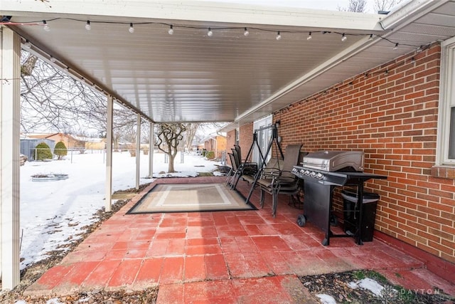 snow covered patio with a grill