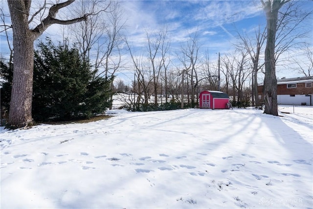 snowy yard with a storage shed