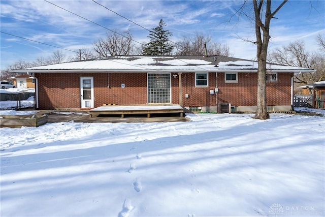 snow covered house featuring cooling unit