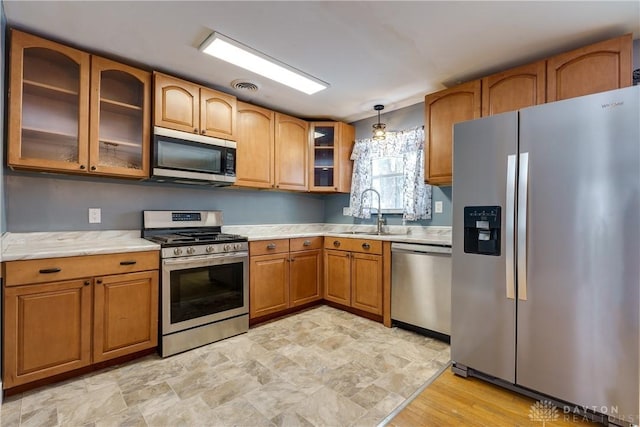 kitchen with sink, decorative light fixtures, and appliances with stainless steel finishes