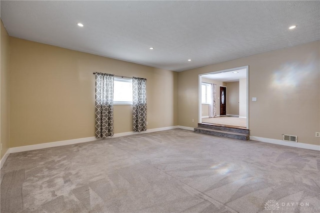 carpeted spare room featuring a textured ceiling