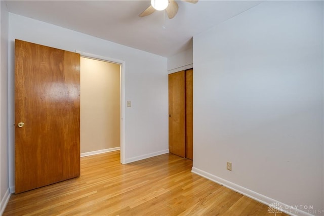 unfurnished bedroom with light hardwood / wood-style floors, a closet, and ceiling fan