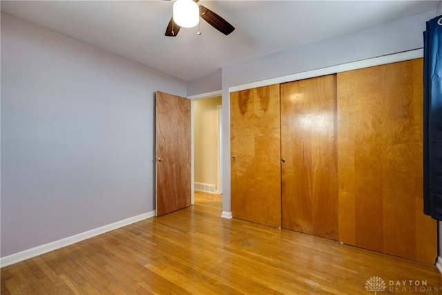 unfurnished bedroom with light hardwood / wood-style floors, a closet, and ceiling fan