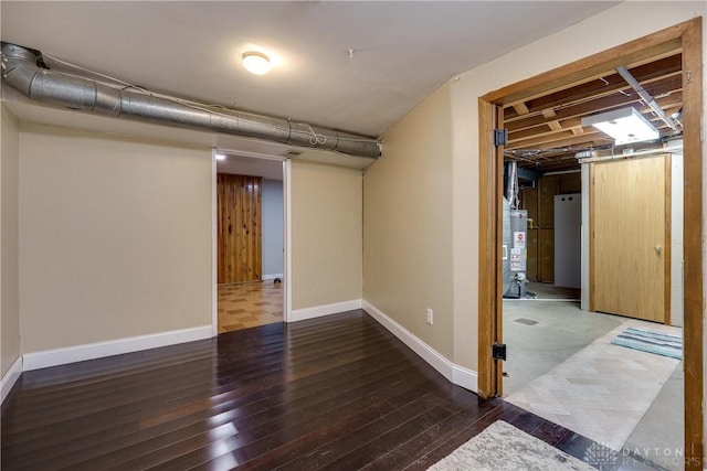 basement with hardwood / wood-style floors, gas water heater, and refrigerator