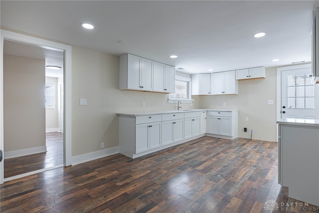 kitchen with sink, white cabinets, and dark wood-type flooring