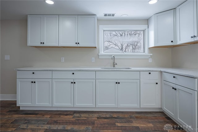 kitchen featuring sink, white cabinetry, and dark wood-type flooring