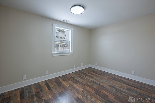 empty room with dark hardwood / wood-style flooring