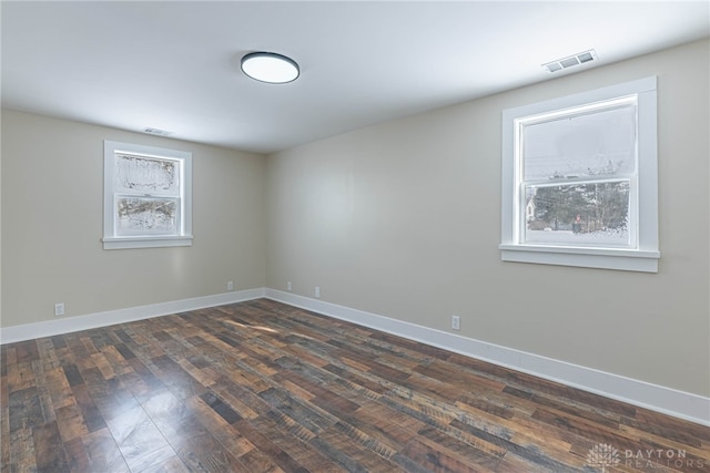 unfurnished room with dark hardwood / wood-style flooring