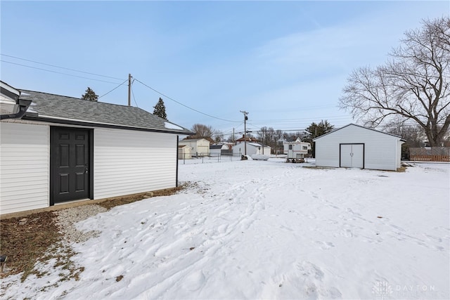 yard covered in snow with a storage shed