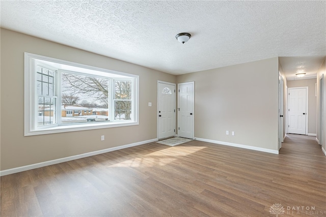 foyer with wood-type flooring and a textured ceiling