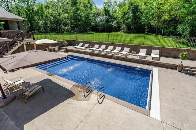 view of pool featuring a patio and a yard