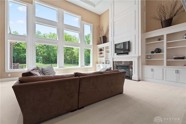 living room featuring light colored carpet, plenty of natural light, and a towering ceiling