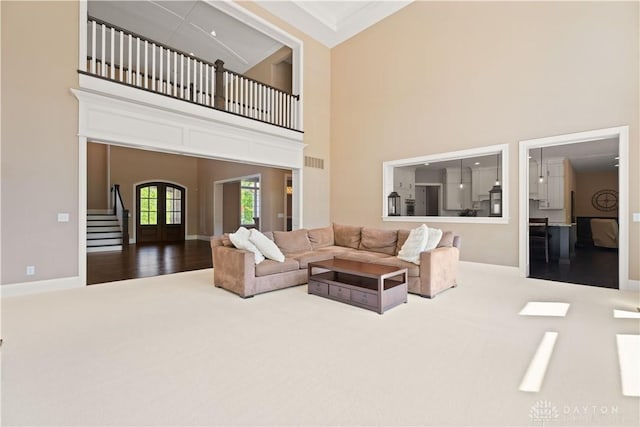 carpeted living room with french doors and a high ceiling