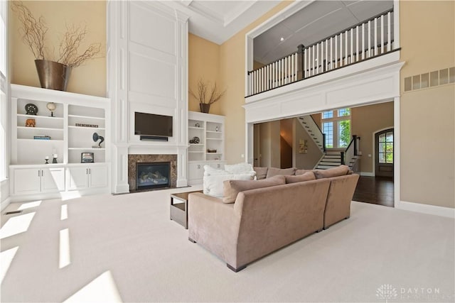 carpeted living room with a high ceiling and a fireplace