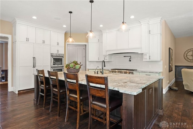 kitchen featuring decorative light fixtures, white cabinetry, and a spacious island