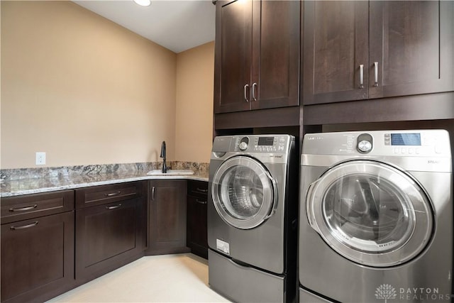 laundry area featuring washer and dryer, cabinets, and sink