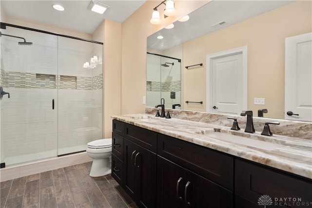 bathroom with toilet, vanity, and an enclosed shower