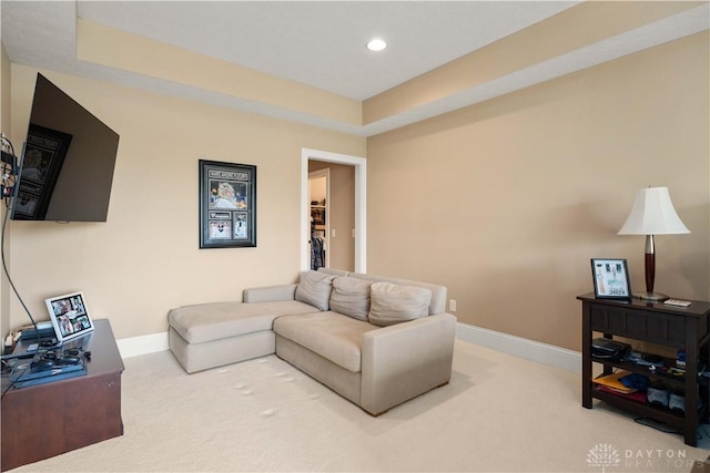 carpeted living room with a tray ceiling