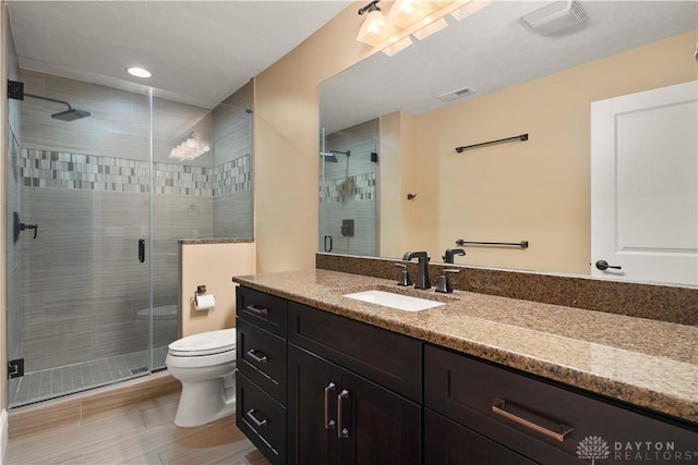 bathroom with toilet, vanity, and walk in shower