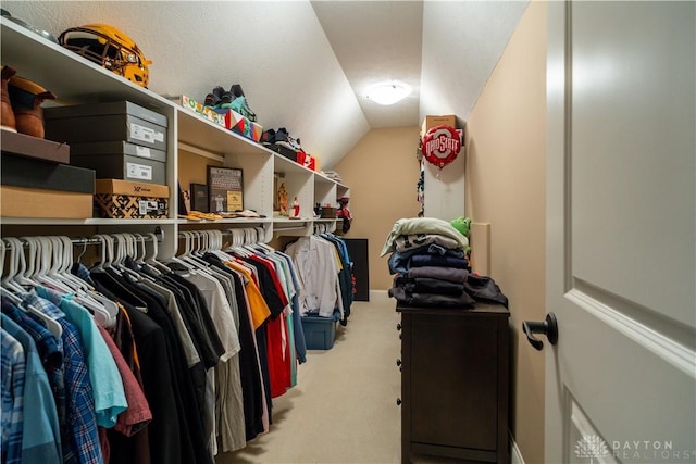 spacious closet featuring light carpet and lofted ceiling