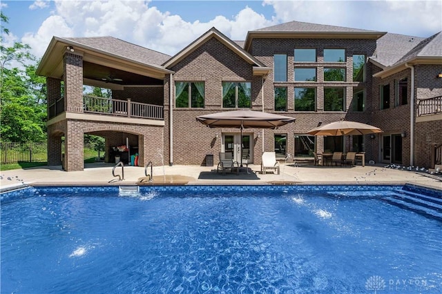 back of house featuring ceiling fan, a fenced in pool, and a patio