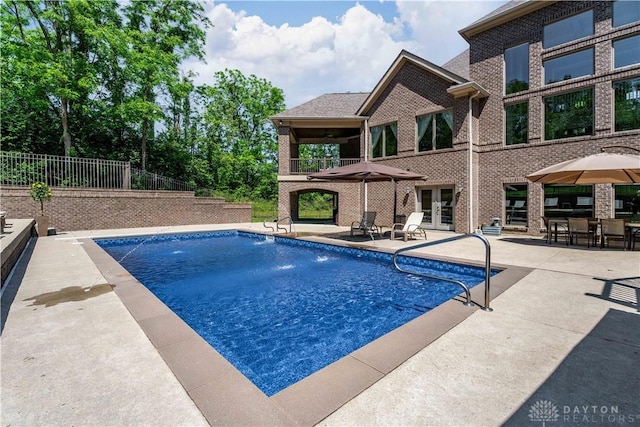 view of pool featuring pool water feature, a patio area, and french doors