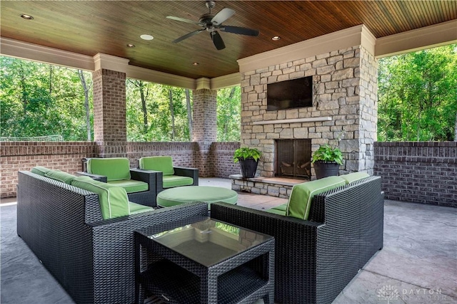 view of patio with an outdoor living space with a fireplace and ceiling fan