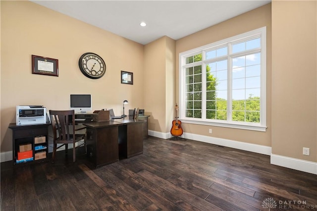 home office with plenty of natural light and dark hardwood / wood-style floors