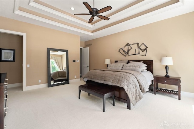 carpeted bedroom featuring ceiling fan and a tray ceiling