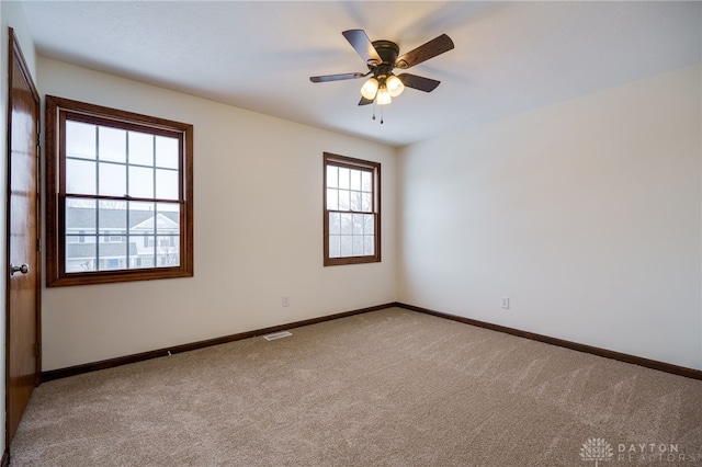 spare room with ceiling fan and carpet