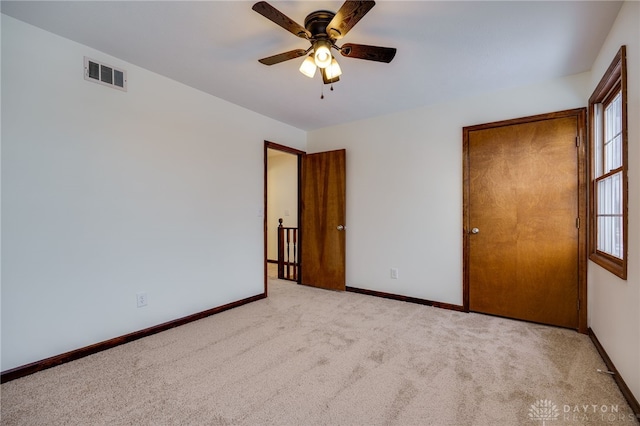 carpeted spare room with plenty of natural light and ceiling fan