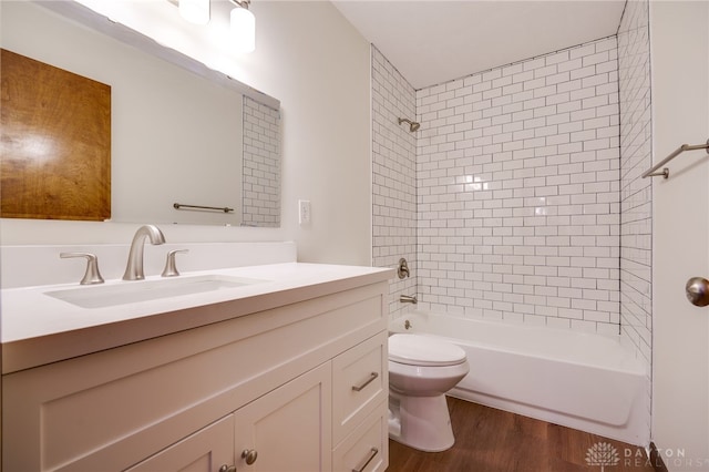 full bathroom featuring vanity, hardwood / wood-style floors, toilet, and tiled shower / bath