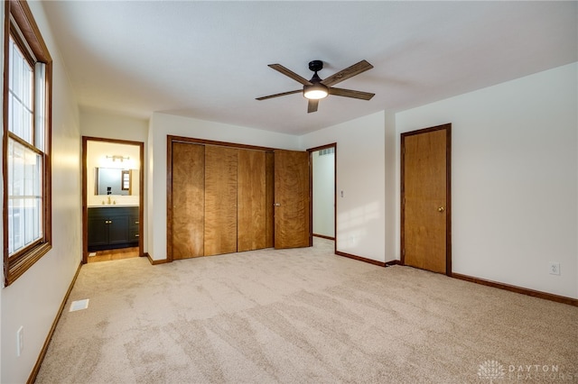 unfurnished bedroom with ceiling fan, ensuite bathroom, sink, and light carpet