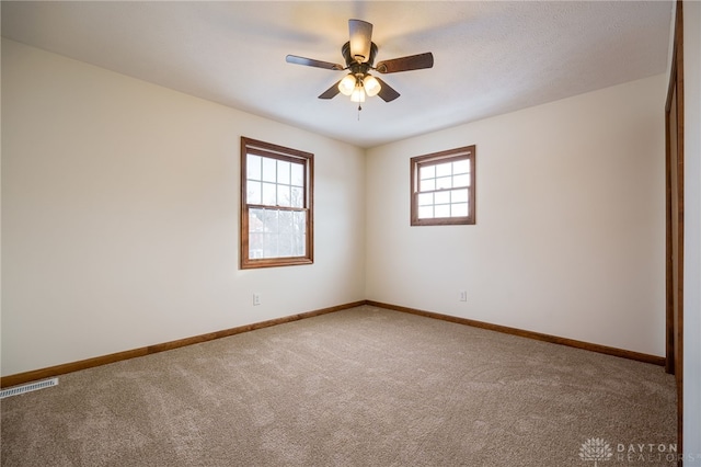 empty room with ceiling fan and carpet flooring