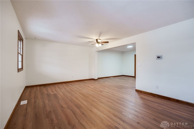 empty room with hardwood / wood-style floors and ceiling fan