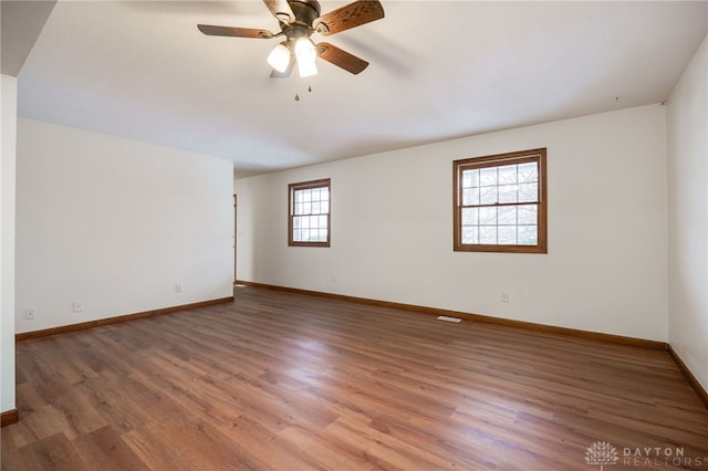 spare room with dark wood-type flooring and ceiling fan