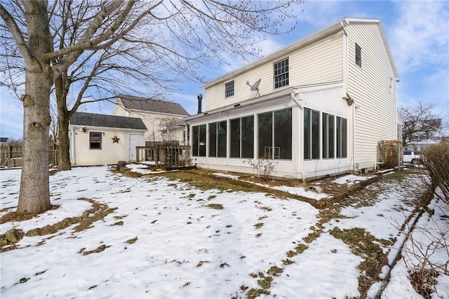 snow covered back of property with a storage shed