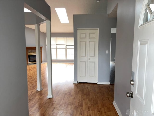 corridor featuring decorative columns and dark hardwood / wood-style floors