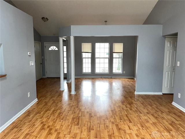 entrance foyer with baseboards, decorative columns, and light wood-style floors