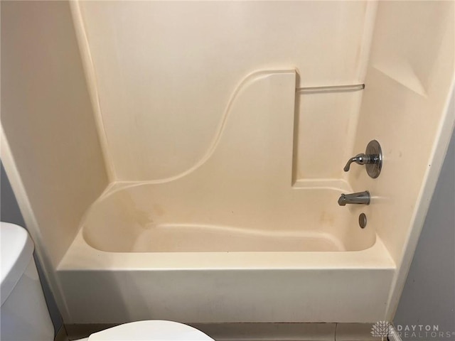 bathroom with toilet and shower / bathing tub combination