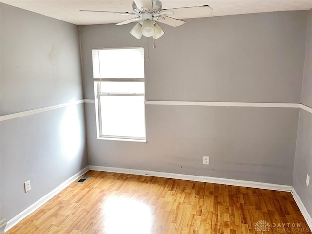 empty room with ceiling fan, a healthy amount of sunlight, and light hardwood / wood-style floors